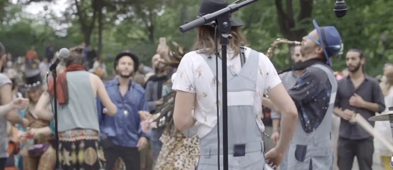 Still from the live video where Bicycle Beat plays among an outdoor crowd.