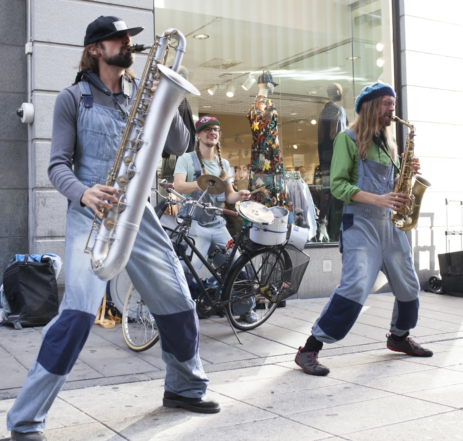 Två saxofonister och en cykel spelar utanför en butik på Drottninggatan.